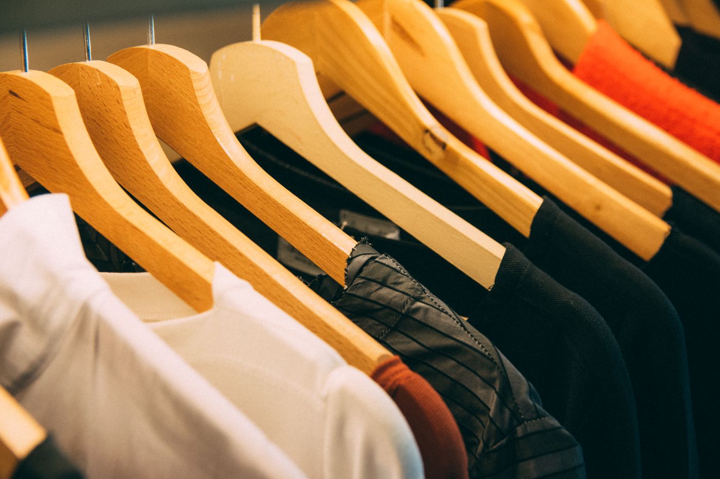 Assorted apparel displayed on wooden hangers